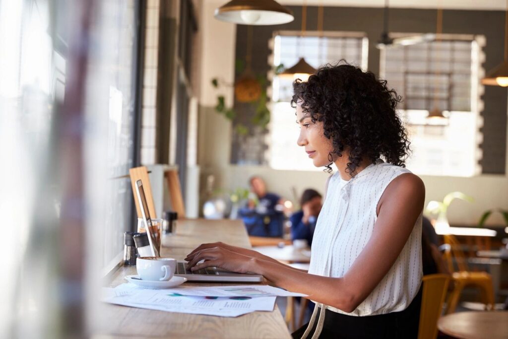 Woman working on laptop in café.